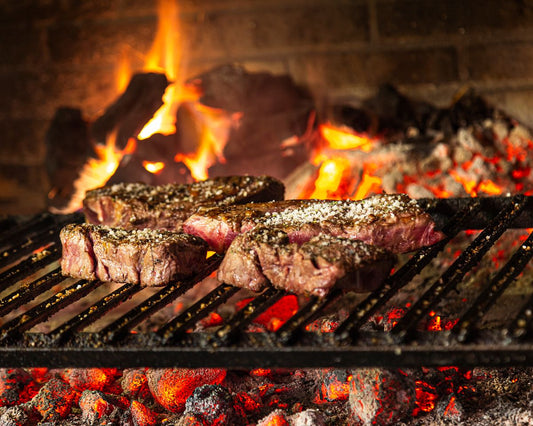 Bifes grelhando sobre a brasa na churrasqueira